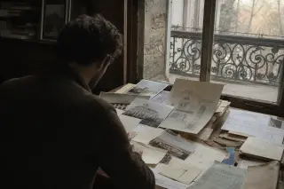 Researcher studying historic villa documents at a wooden desk in a softly lit archive, with a glimpse of an old balcony outside the window and a contemplative, subdued atmosphere.